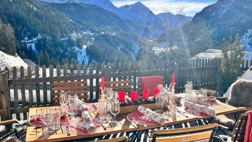 a table with red candles and glasses on top of a mountain at Chalet Im Wieselti in Langwies