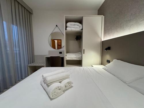 a bedroom with a white bed with towels on it at Residence le Spiagge in Rimini