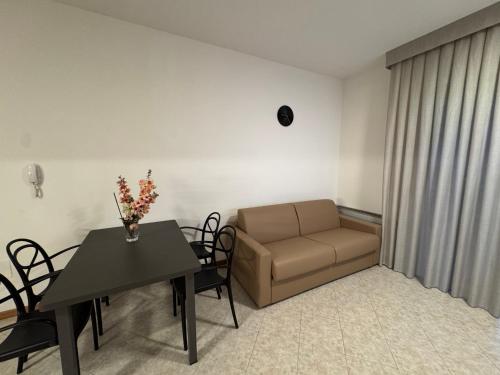 a living room with a table and a couch at Residence le Spiagge in Rimini