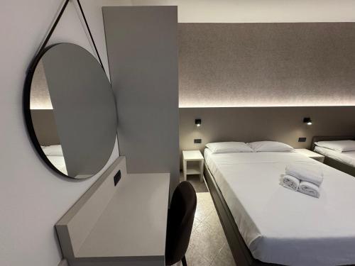 a hotel room with a bed and a mirror at Residence le Spiagge in Rimini