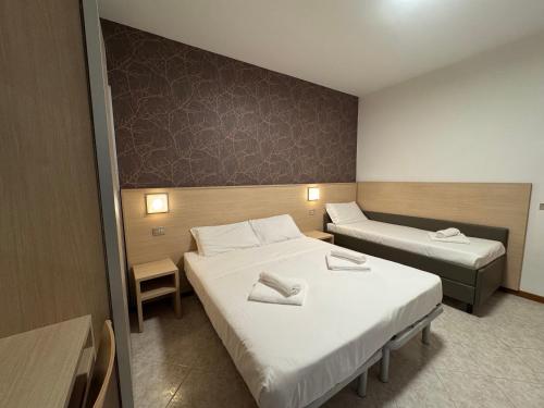 a hotel room with two beds and a bed istg at Residence le Spiagge in Rimini