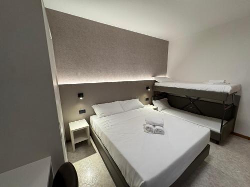 a small room with two beds and a small table at Residence le Spiagge in Rimini