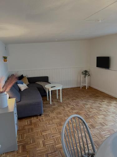 a living room with a couch and a table at Gæstehuset Husly in Haderup