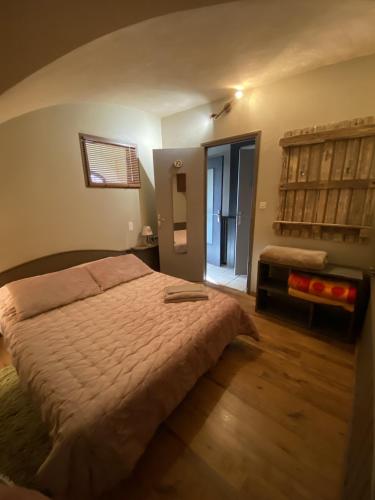 une chambre avec un grand lit et une fenêtre dans l'établissement La Rose des Vents, à Saint-Bonnet-en-Champsaur