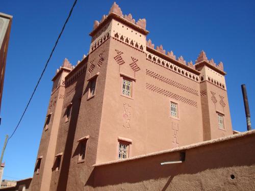 a large brick building with writing on the side of it at Kasbah Ait Kassi in Boumalne