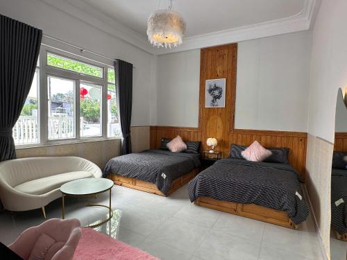 ein Schlafzimmer mit zwei Betten und einem Stuhl in der Unterkunft Thái Bảo Châu PHT - Homestay in Khu Chi Lăng