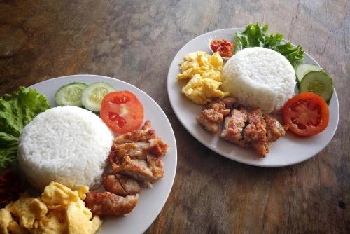 due piatti di cibo con riso e verdure su un tavolo di Rumah Bata Salatiga a Salatiga