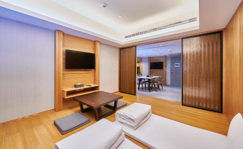 a living room with a television and a table at Grand Bay Resort Hotel in Hengchun