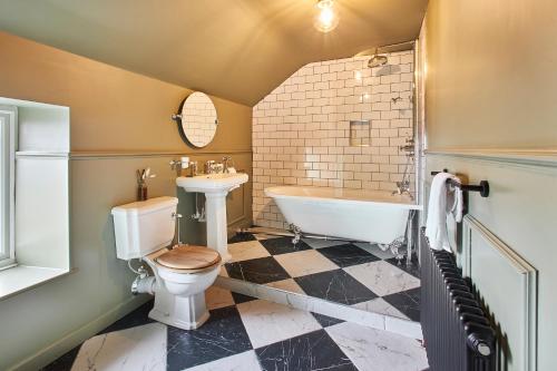 a bathroom with a toilet and a tub and a sink at Alnwick 2 Bed Cottage Stay, Joe's Cottage in Alnwick