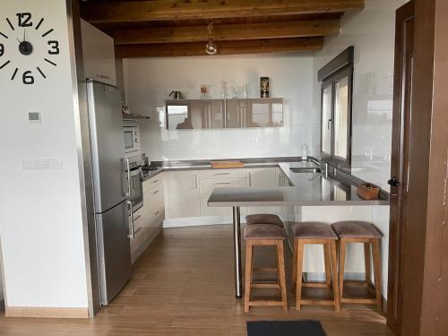 een keuken met een tafel en wat krukken erin bij Casa con vistas impresionantes in A Coruña