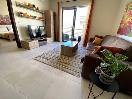 a living room with a couch and a table at Cara Flats By Homely in Mellieħa
