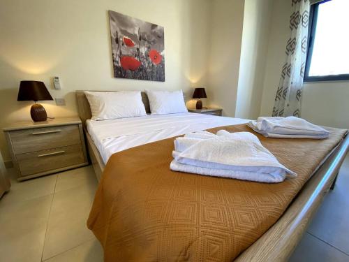 a bedroom with two beds with towels on them at Cara Flats By Homely in Mellieħa
