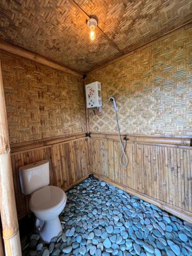 a bathroom with a toilet and a shower at Kelimutu Paradiso Resort in Kelimutu