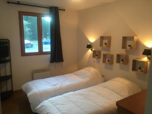 a bedroom with a white bed and a window at Pied des pistes à Molines en Queyras in Molines-en-Queyras