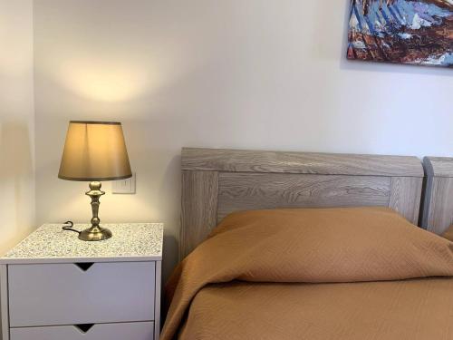 a bedroom with a bed and a table with a lamp at Cara Flats By Homely in Mellieħa