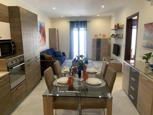 a kitchen and living room with a table and chairs at Cara Flats By Homely in Mellieħa