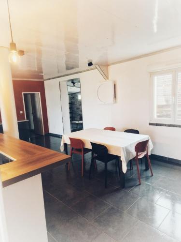 une salle à manger avec une table et des chaises blanches dans l'établissement chalonnaise house 120m2, à Châlons-en-Champagne