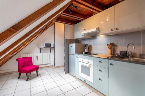 - une cuisine avec une chaise rouge dans la chambre dans l'établissement Logement atypique avec mezzanine, à Lingolsheim