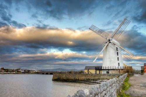 a windmill in the middle of a body of water at Apartment-Sleeps2-Parking-Garden-Patio in Castleisland