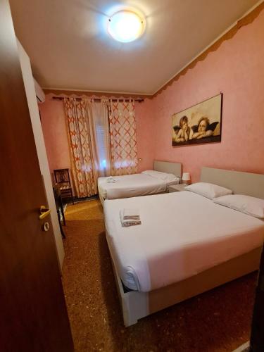 two beds in a room with pink walls at Er Centurione in Rome