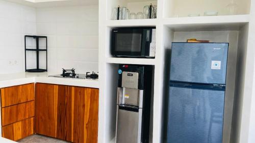 una cocina con nevera y microondas en Best Deals - New Fancy 2BR Private Pool Villa, en Uluwatu