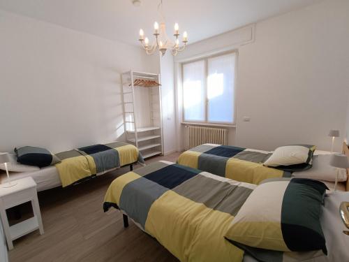 a room with four beds and a chandelier at Casa vacanze Orobie in Villa di Tirano