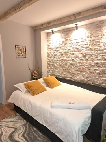 a bedroom with a brick wall and a bed at Casa Ileana Centrul Vechi Brasov in Braşov