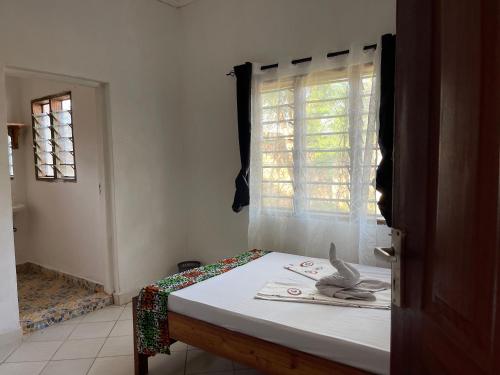 ディアニ・ビーチにあるCozy 2Bdrm Chill out Villa with Private Yardの窓とテーブル付きのベッドが備わる客室です。