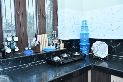 a kitchen counter with a stove and a bottle of water at Happy Home in Jaipur