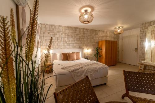 a bedroom with a bed in a room with plants at Estate Spa Boutique Hotel - Adults Only in Rechovot