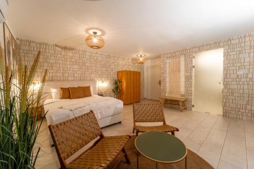 a bedroom with a bed and a table and chairs at Estate Spa Boutique Hotel - Adults Only in Rechovot