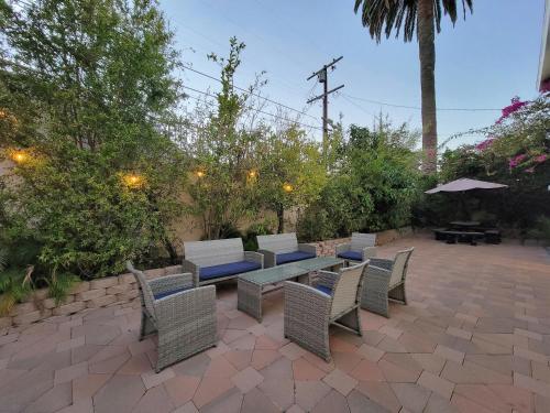 a patio with a table and chairs and an umbrella at 3 bedroom apartment by the MrC Hotel and 5 minutes to Rodeo Drive WiFi TV Patio walk to restaurants in Los Angeles