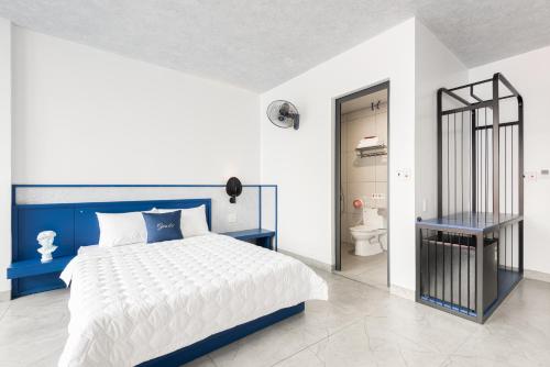 a blue and white bedroom with a bed and a toilet at GARE D'47 l 21 Lê Chân street l Đối diện Nhà hát lớn in Hai Phong