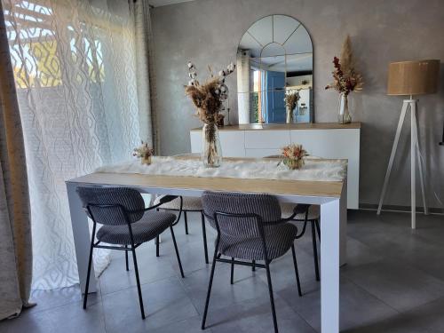 - une table à manger avec des chaises et un miroir dans l'établissement Maison entre mer et montagnes, à La Gaude