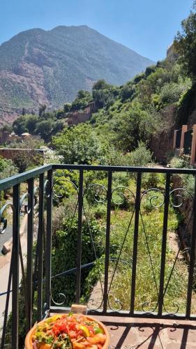a pizza on a balcony with a view of a mountain at Villa Romancia Ourika Vallee in Marrakech