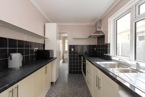 グレーズ・サロックにあるLovely 2 Bed Room House in Graysの大きなキッチン(シンク、窓付)