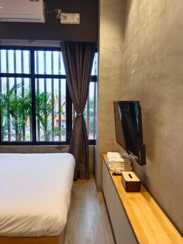 a bedroom with a bed and a tv and a window at Caldwell Boutique Hotel in Legazpi