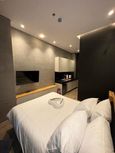 a large white bed in a room with a kitchen at Caldwell Boutique Hotel in Legazpi