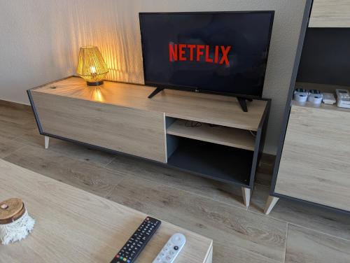 a tv sitting on top of a entertainment center at Vive Santa Pola - Relax y tranquilidad junto al mar in Santa Pola