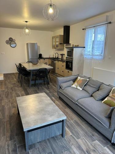 un salon avec un canapé et une table dans l'établissement Maison tout confort 2 chambres, à Saint-Pierre-de-Varengeville