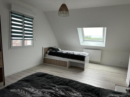 une chambre blanche avec un lit et une fenêtre dans l'établissement Maison tout confort 2 chambres, à Saint-Pierre-de-Varengeville