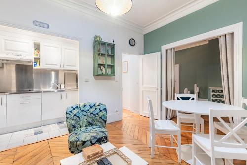 une cuisine et une salle à manger avec une table et des chaises dans l'établissement Top Appartement Avenue Ternes Paris, à Paris