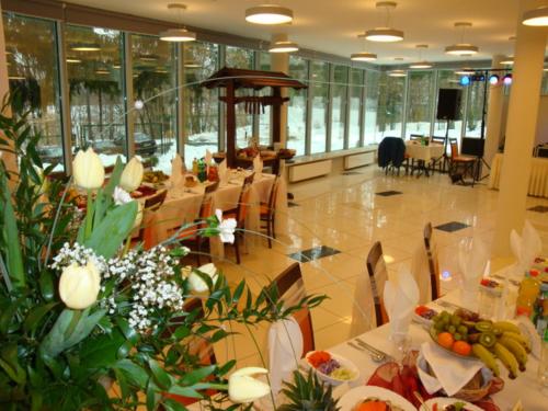 a restaurant with a table with fruits and vegetables on it at Hotel Ameliówka in Masłów