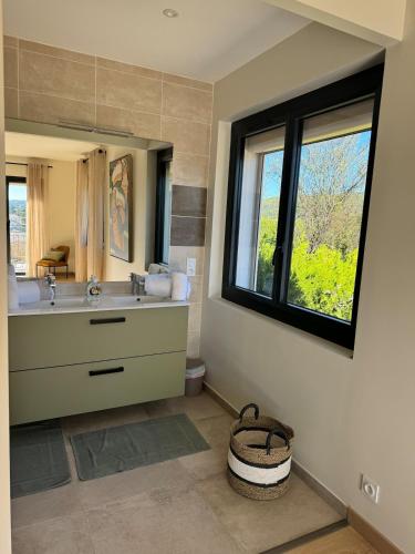 une salle de bain avec un lavabo et un grand miroir dans l'établissement Villa de Marie 10 personnes piscine, à Vaison-la-Romaine