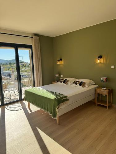 une chambre avec un grand lit et une grande fenêtre dans l'établissement Villa de Marie 10 personnes piscine, à Vaison-la-Romaine