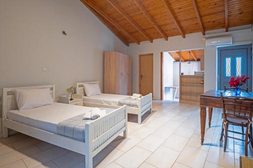 a bedroom with two beds and a table and a desk at Nona's House in Romanu