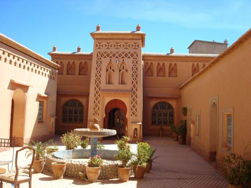 a courtyard with a fountain in front of a building at Kasbah Ait Kassi in Boumalne