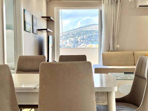 a dining room with a table and chairs and a window at Amazing Sea View Apartment in Sarandë