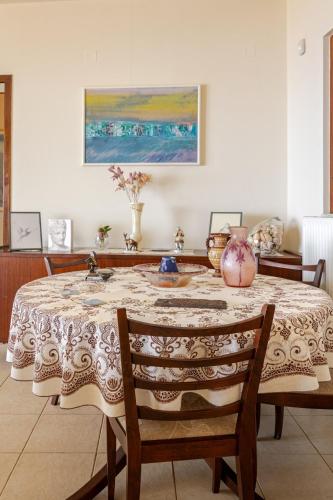 a dining room with a table with a vase on it at Villa Panorama in Makry Gialos