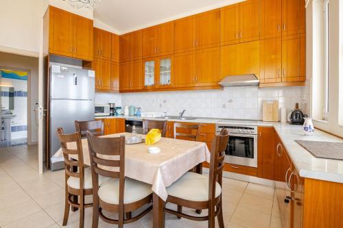 a kitchen with a table and some wooden cabinets at Villa Panorama in Makry Gialos